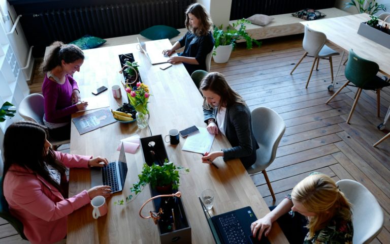 a group of people sitting around a wooden table
