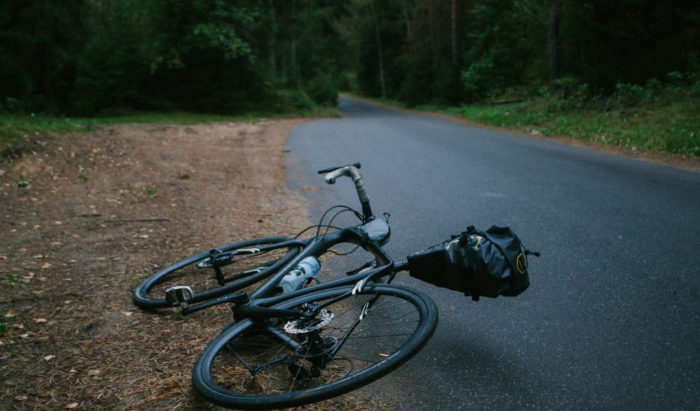 black road bike lying on asphalt road during daytime